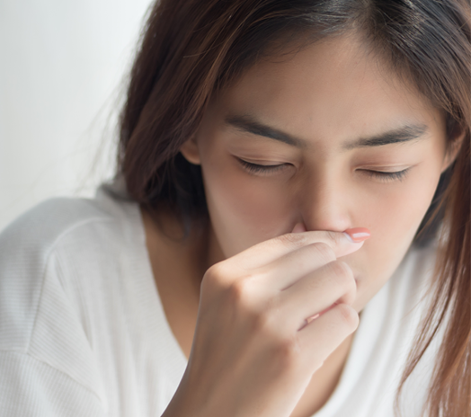 woman holding her nose. Nasal polyps treatment