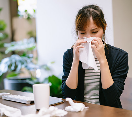 woman wiping her nose with a tissue